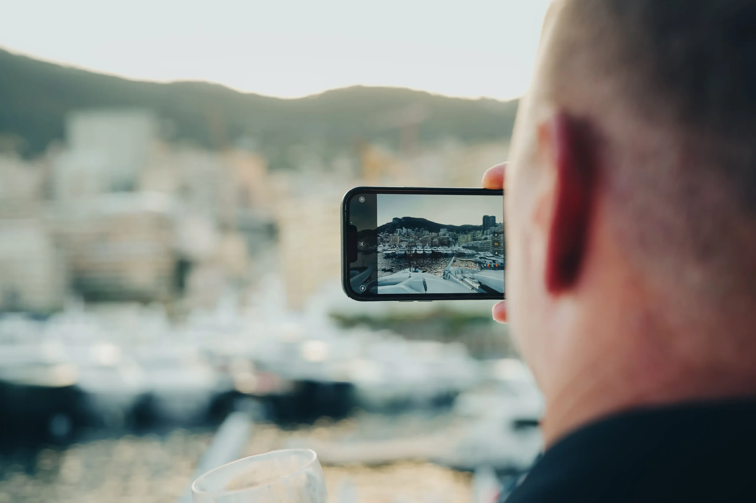 persona che fotografa il panorama di un porto francese